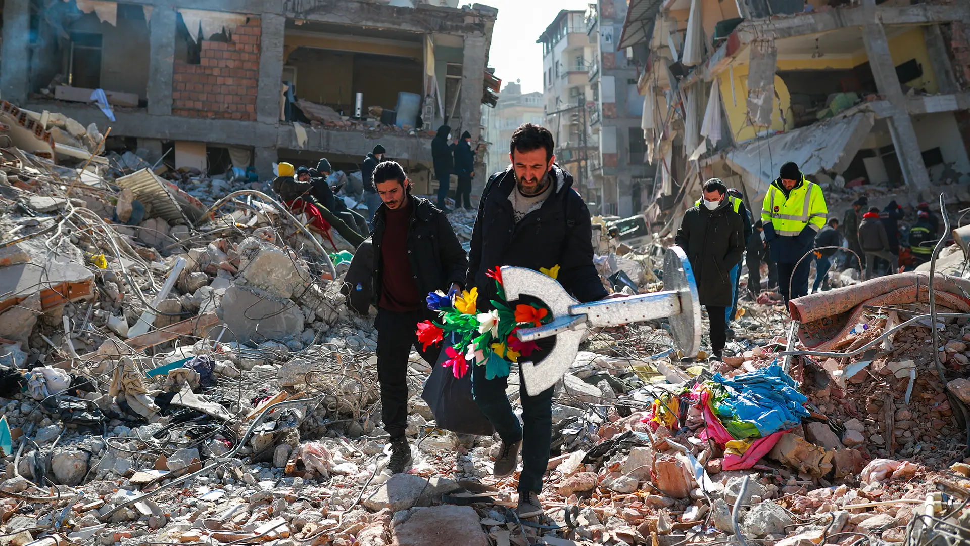 Het glinsterende goocheltafeltje en de kleurrijke goochelbloemen van de Turkse goochelaar Orhan Balta staan in schril contrast met de door de aardbevingen verwoeste omgeving.